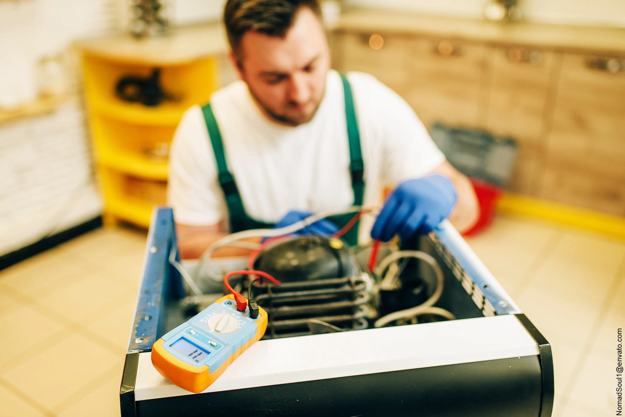 Elektrofachkraft der i-Arbeitsschutz Service GmbH führt mit einem Messgerät die Wartung und Prüfung an der Elektronik einer ortsfesten Anlage durch.