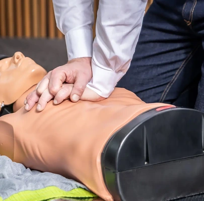 Reanimation bei Erste-Hilfe-Kurs – Ersthelfer übt Herzdruckmassage am Arbeitsplatz