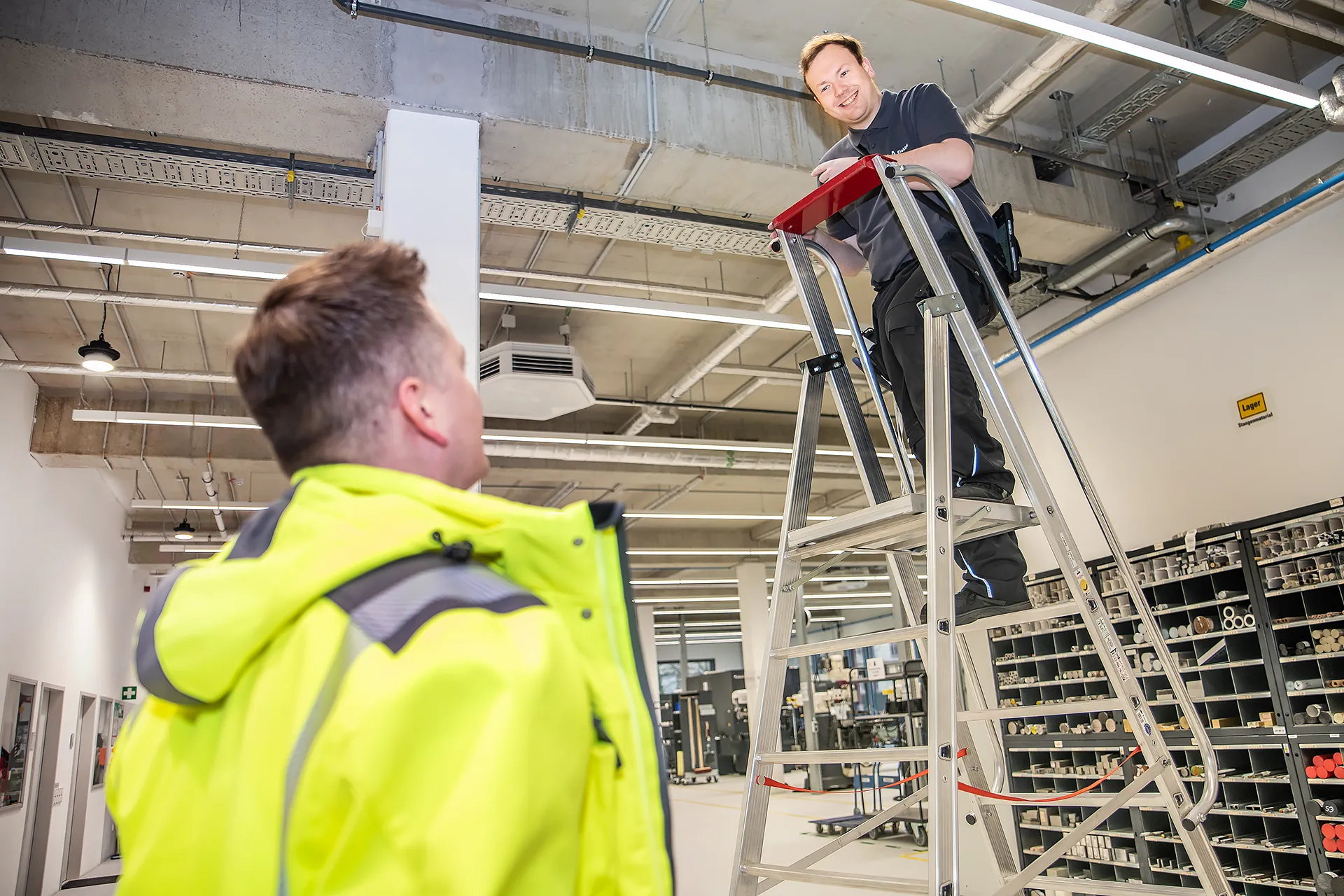 Fachkraft für Arbeitssicherheit im Gespräch mit Elektriker auf der Baustelle